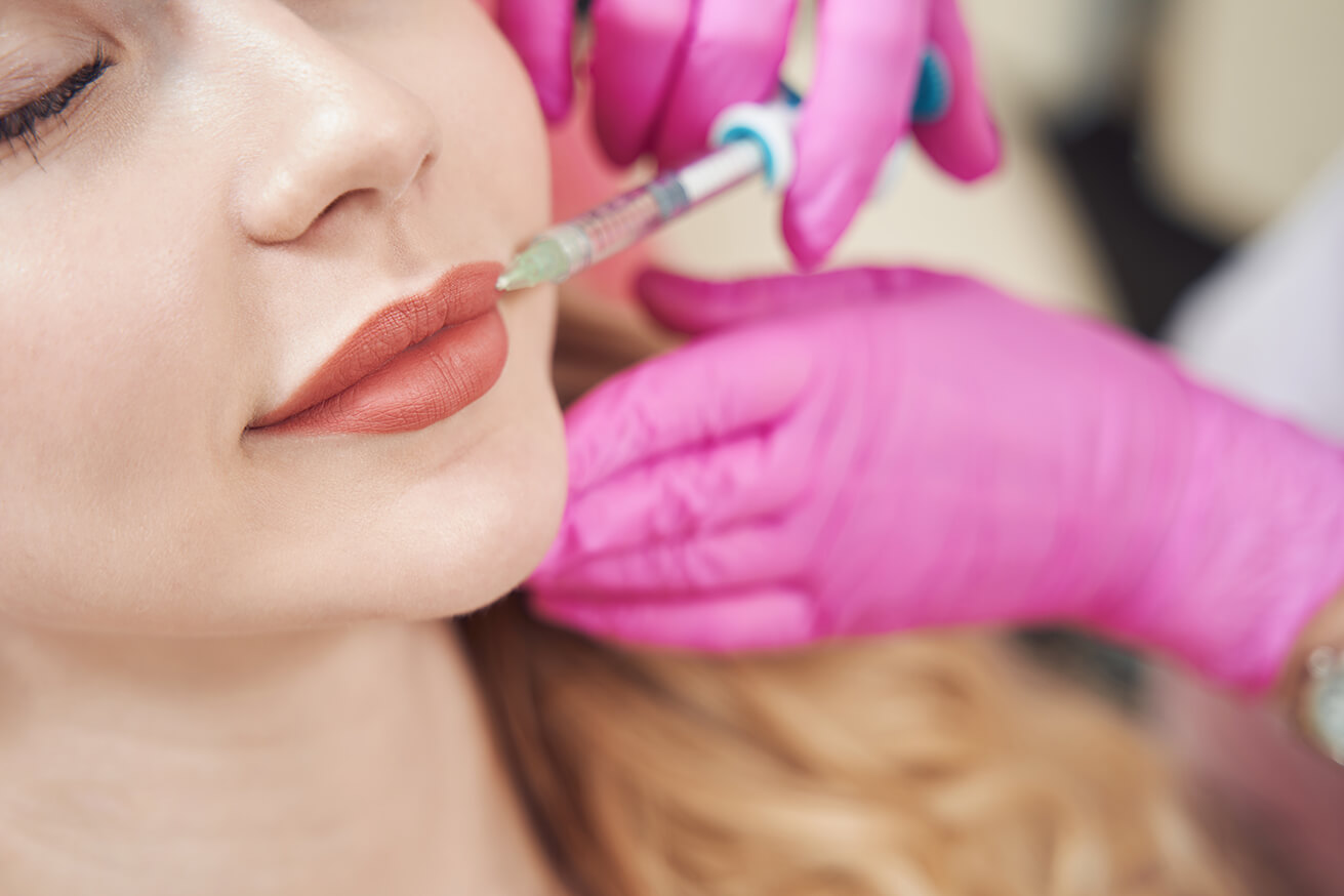 Happy pretty woman getting lip augmentation and correction procedure in salon